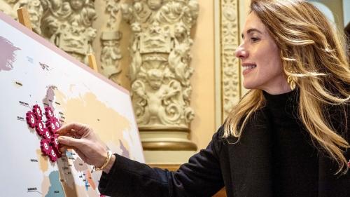 Embajadora coloca insignia en el mapamundi de la red.